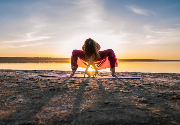 Yoga-Frau am Strand bei Sonnenuntergang. - Foto, Bild