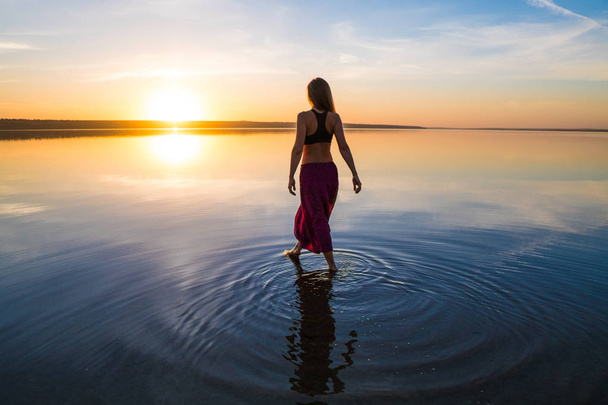Σιλουέτα γυναίκα γιόγκα στην παραλία το ηλιοβασίλεμα. - Φωτογραφία, εικόνα