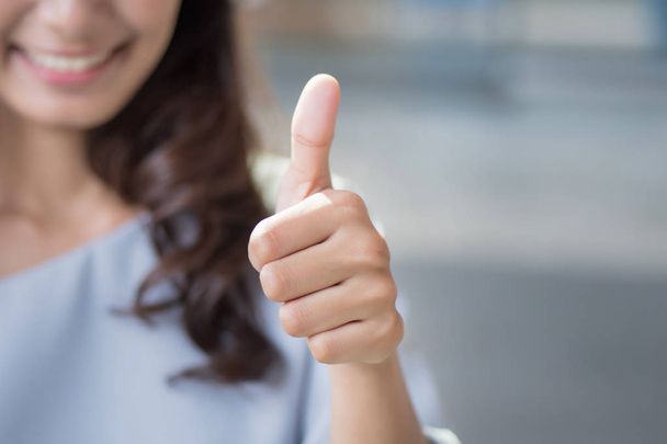 successful girl pointing thumb up; portrait of cheerful smiling woman pointing up approving, yes, ok, good, thumb up gesture; asian woman young adult model - Photo, Image