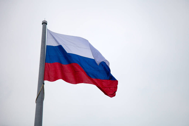 Ruská vlajka na stožáru proti modré obloze - Fotografie, Obrázek
