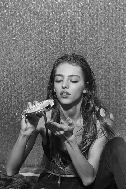 girl is making herself a make-up. Pretty sexy girl putting glittering mousse on long blond hair - Foto, Imagen