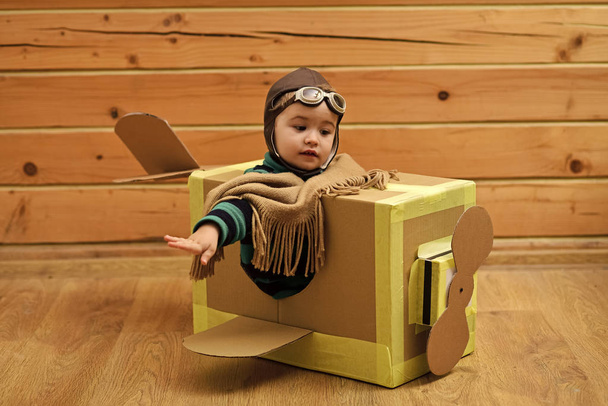 выбор профессии. Маленький ребенок в костюме пилота мечтает пилотировать самолет
 - Фото, изображение