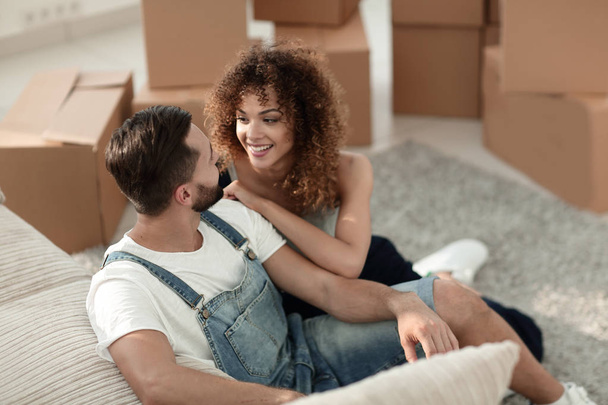 Young couple sitting on the floor in a new apartment - Photo, image