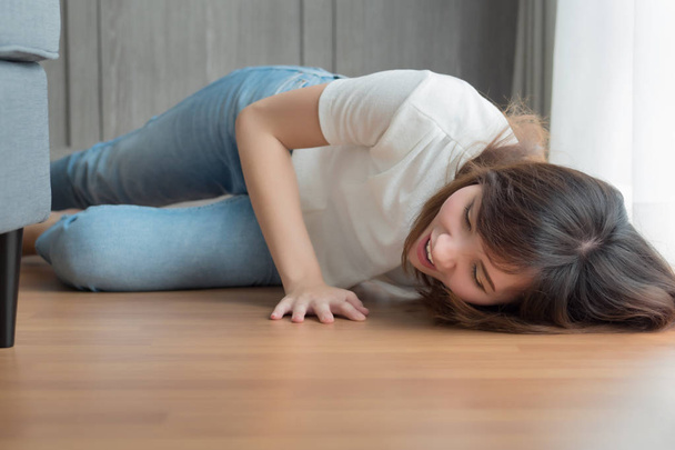 injured woman falls down due to slippery floor; portrait of asian woman falling down, breaking her back, leg, knee, arm, hand bone due to slippery floor accident, 30s adult asian chinese woman model - Photo, Image