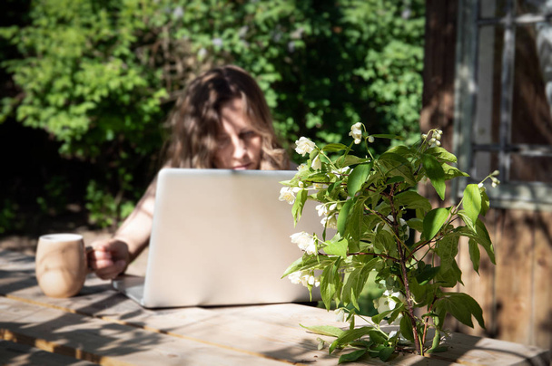 Trabajo con computadora al aire libre por mesa de madera en el campo, trabajo desde casa
 - Foto, Imagen