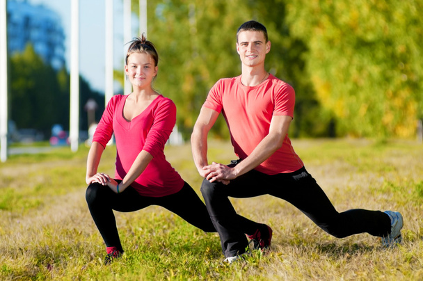 Man and woman woman doing yoga in park - Photo, image