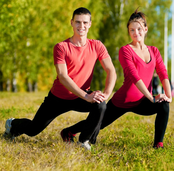 Man and woman woman doing yoga in park - Photo, image
