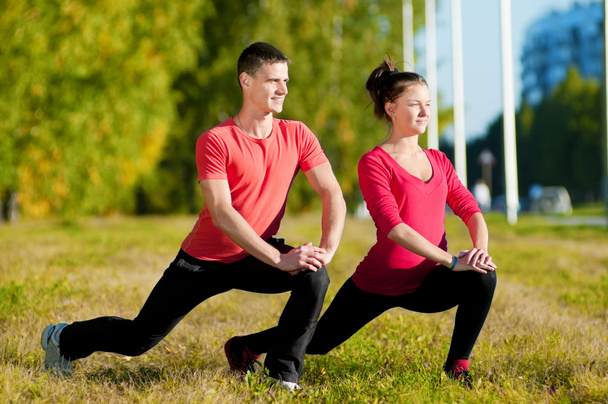 Man and woman woman doing yoga in park - Foto, Imagen