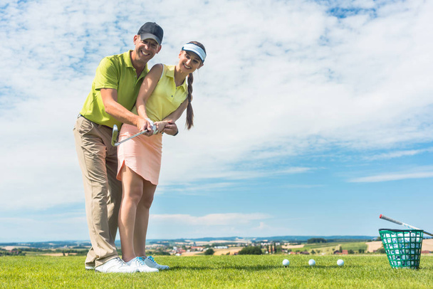 junge Frau übt den richtigen Zug beim Golfkurs mit einer erfahrenen Spielerin - Foto, Bild