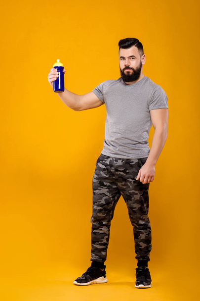 Handsome strong man drinks water - Foto, afbeelding