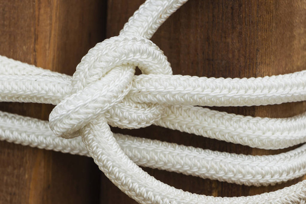 White rope with a knot on wooden background - Photo, Image