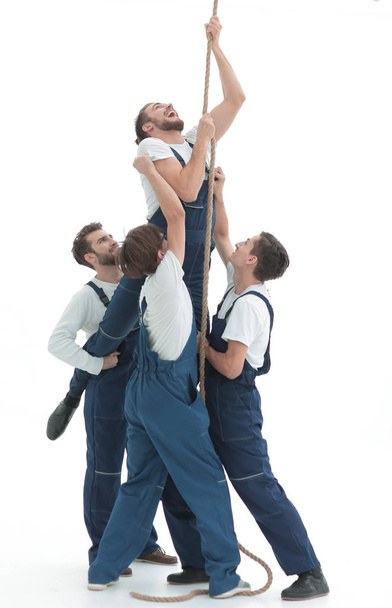group workers help the companion to climb up - Foto, imagen