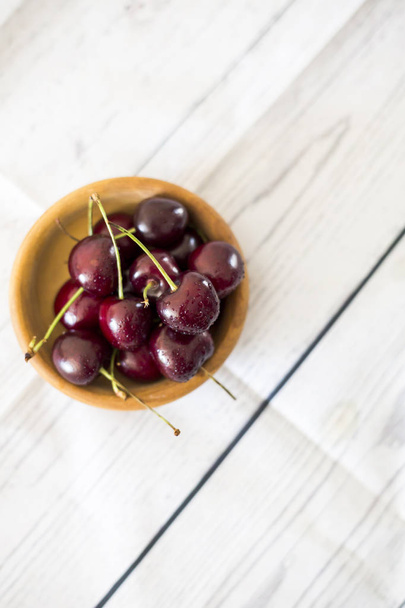 cherries in wooden bowl close up  - Фото, зображення