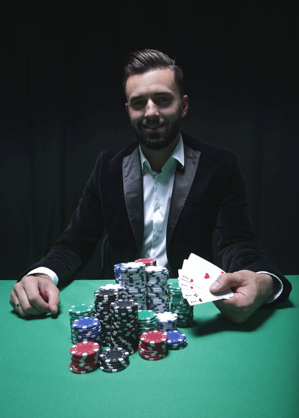 Happy poker player winning and holding a pair of aces - Foto, imagen