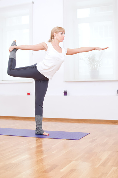 Woman doing stretching yoga exercise at sport gym - Fotó, kép