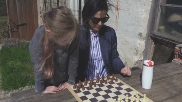 Mother teaching daughter playing chess - Footage, Video