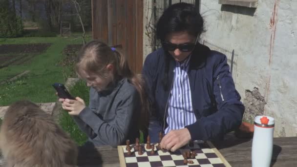 Frau, Tochter und Katze in der Nähe des Schachbretts - Filmmaterial, Video
