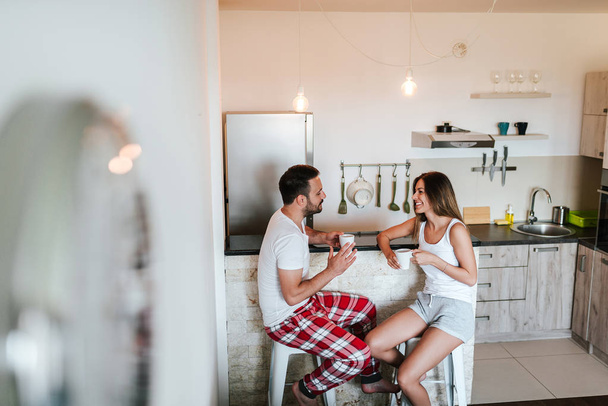 Couple in pajamas drinking morning coffee. - Foto, Imagen