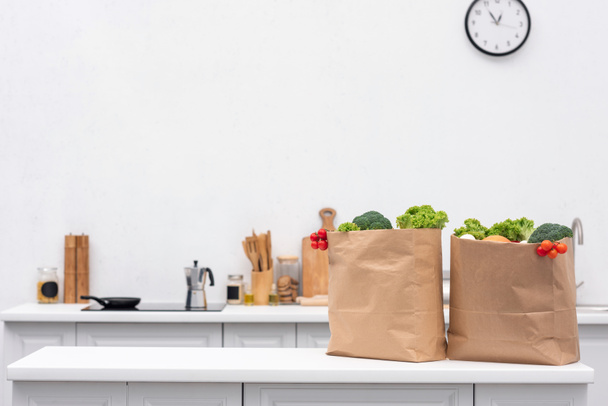 élelmiszerbolt táskák zöldségekkel konyha asztalon - Fotó, kép