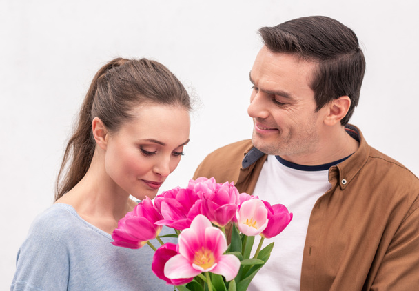 happy adult man presenting tulips bouquet for wife - Zdjęcie, obraz