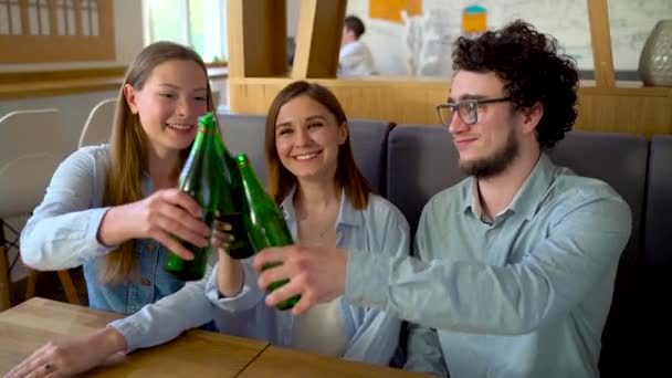 Three friends sit in a cafe, drink water or beer and have fun communicating - Filmmaterial, Video