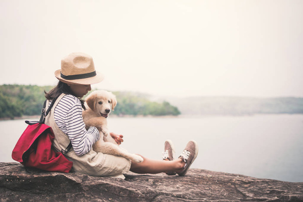 Happy girl playing with little dog in nature background, travel on holiday color of vintage tone and soft focus - Zdjęcie, obraz