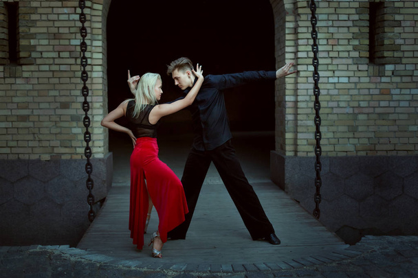 Paar professioneller Tänzer, die Tango aufführen. der Typ mit dem Mädchen tanzt den Tanz der Liebe. - Foto, Bild