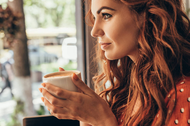 oldalnézet, töprengő nő csésze illatos kávét a café - Fotó, kép