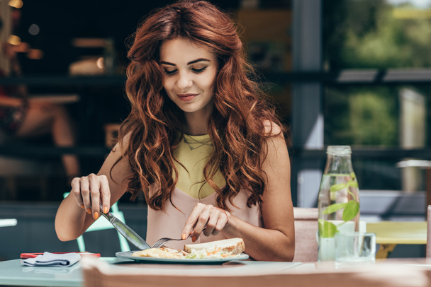 portrait of young woman having lunch alone in restaurant - Photo, Image