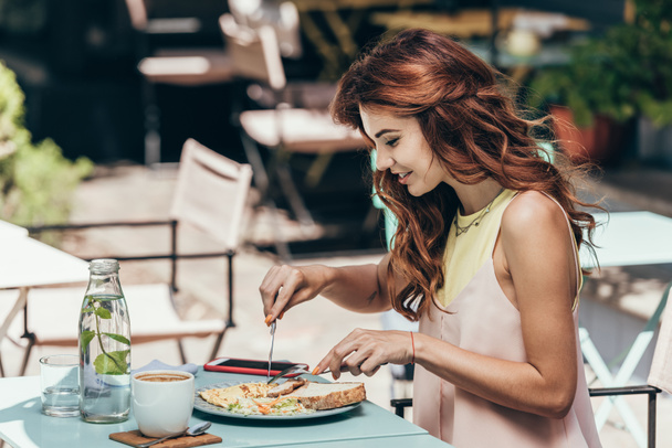 side view of young woman having lunch alone in restaurant - Photo, Image