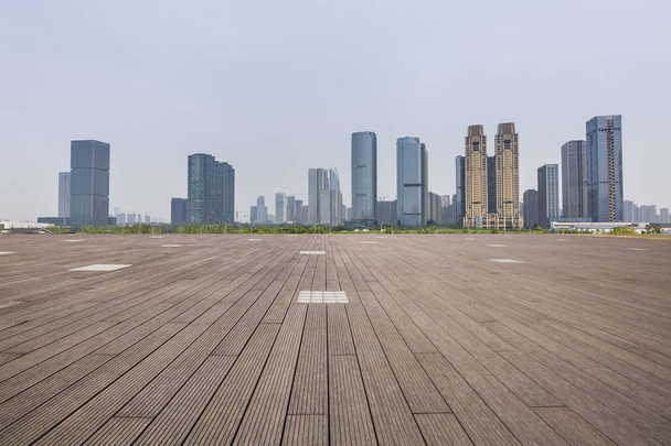 skyline panorámico y modernos edificios de oficinas de negocios con camino vacío, piso cuadrado de hormigón vacío - Foto, imagen