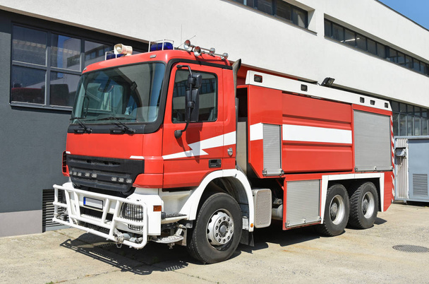 Vehículo de bomberos junto a la estación de bomberos
 - Foto, Imagen
