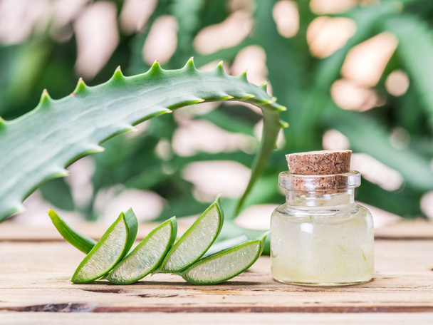 Fresh aloe leaves and aloe gel in the cosmetic jar on wooden table. - Foto, immagini