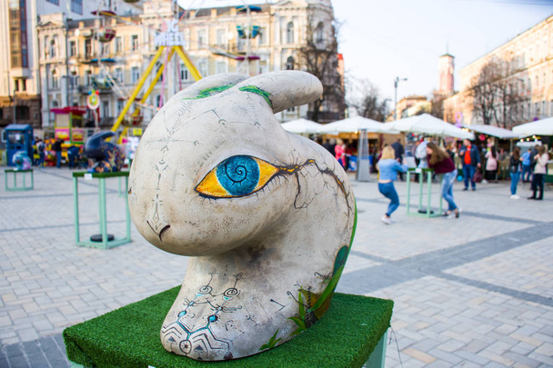 Painted three-dimensional figure of a rabbit or hare with hypnotic yellow eyes with blue iris in grey color. Beautiful art easter decoration. Kyiv Kiev, Ukraine - Фото, изображение