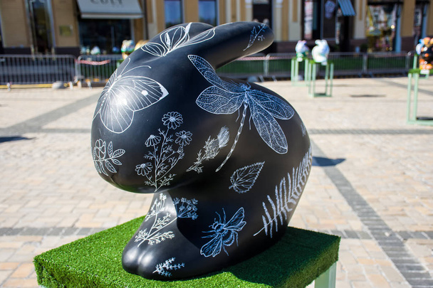 Rabbit or hare figure painted in black with painted silhouettes of insects - butterflies, bumblebees, dragonflies and plants on it. Beautiful Easter art decoration .Kyiv (Kiev), Ukraine, april 2018 - Фото, зображення