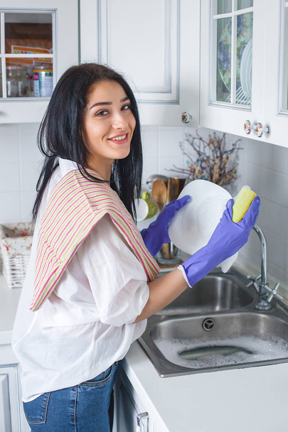 Young attractive woman washing the dish indoors. - Photo, Image
