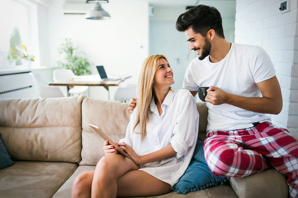 Young attractive couple spending time together at home using tablet - Photo, Image