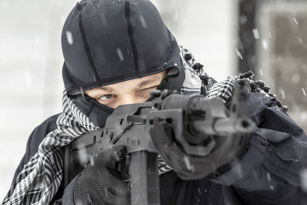 屋外の環境で吹雪の中、武器を撃つ訓練若い軍人. - 写真・画像