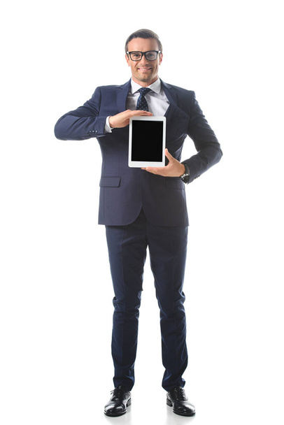 smiling businessman in eyeglasses holding digital tablet with blank screen isolated on white background  - Foto, Imagem