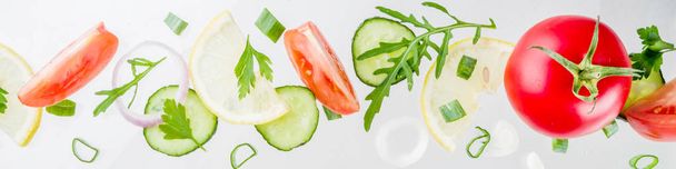 Creative background, layout, concept of fresh healthy diet of salad, fresh raw  vegetables tomatoes parsley onions cucumbers greens, simple pattern on white background banner - Photo, Image