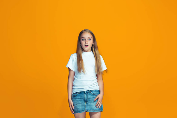 Piękna Nastolatka Dziewczyna patrząc zaskoczony na białym tle na orange - Zdjęcie, obraz