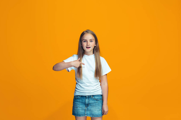 Beautiful female half-length portrait on orange studio backgroud. The young emotional teen girl - Foto, imagen