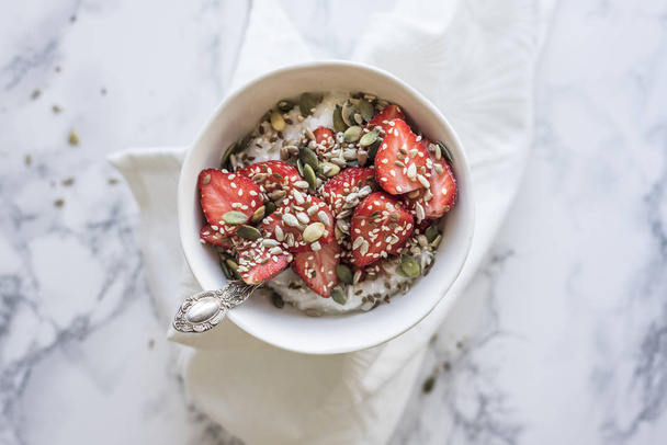 Gezond ontbijt kom met aardbeien en zaden - Foto, afbeelding