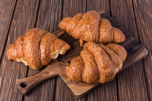 frisch gebackene Croissants auf Holztisch - Foto, Bild