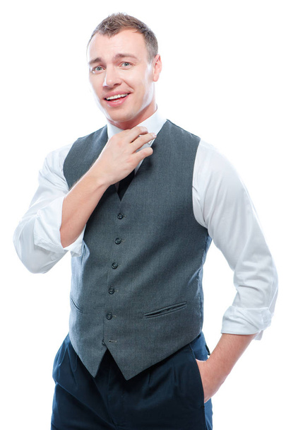 Portrait of happy young man adjusting tie looking at camera isolated on white. - 写真・画像