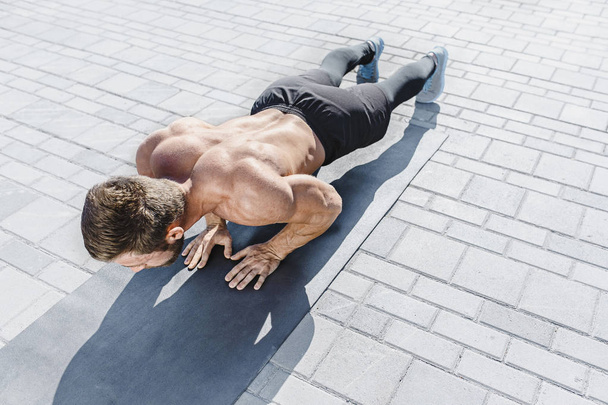 Fit fitness man doing fitness exercises outdoors at city - Foto, Imagem