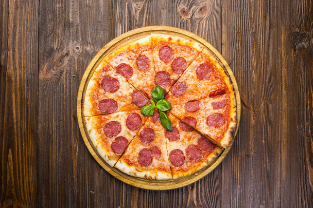Pizza pepperoni, ser mozzarella, salami i rukolą na podłoże drewniane - Zdjęcie, obraz