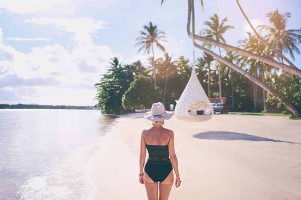 Young woman walking on the beautiful tropical white sand beach resort. - Foto, afbeelding