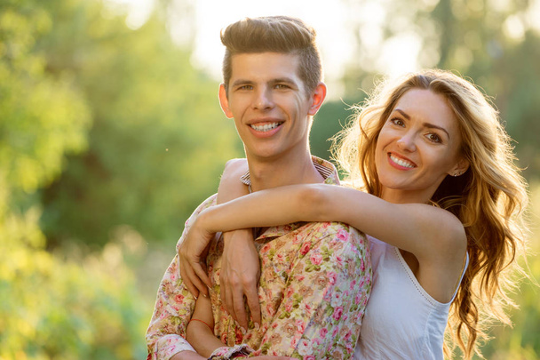 Outdoor portrait of laughing loving couple embracing in park. - Foto, afbeelding