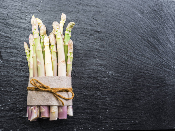 White tender fresh asparagus sprouts on the black background.  Top view. - 写真・画像